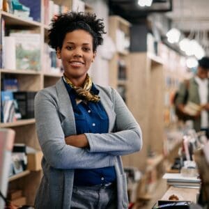 Confident bookstore owner arms crossed.